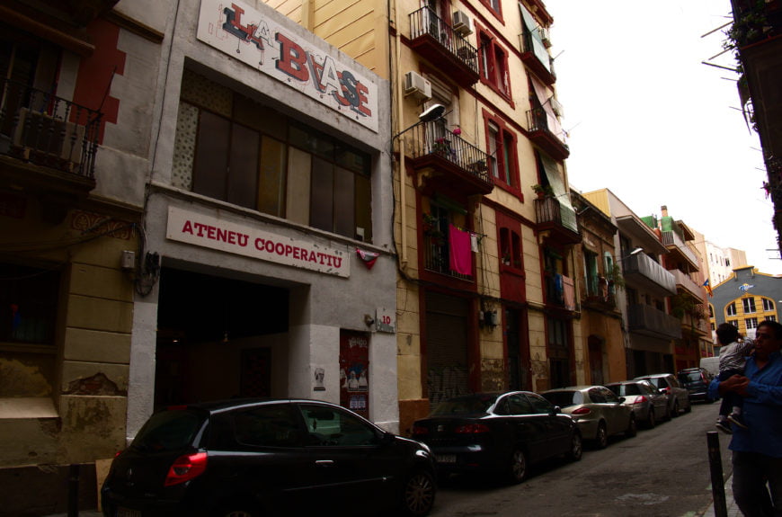 picture of la base in Barcelona with cars in front and a man and child on the right